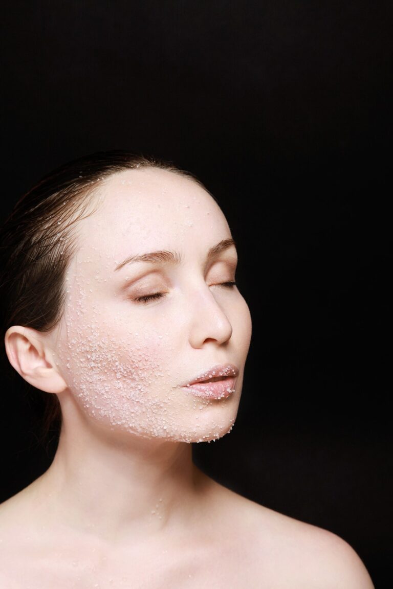 Close-up of a woman with water droplets on her face, highlighting skin hydration and care for inflammation.