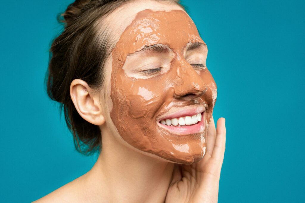 A woman with a clay mask applied to her face, promoting healthy and refreshed skin.