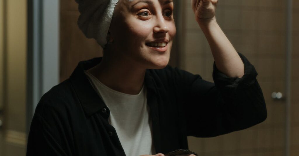 A woman following a gentle night routine for sensitive skin, applying skincare with a soft smile in a cozy, calm bathroom setting.